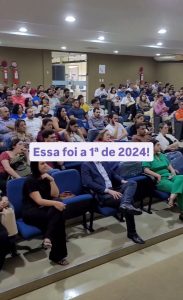 Colaboradores em um auditório participando de uma reunião